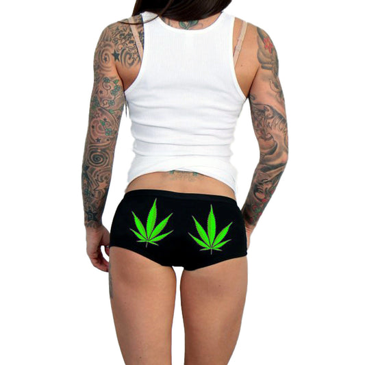 This image features a pair of women's boy shorts, designed with a bold and graphic print. The shorts are black, providing a sleek background that contrasts vividly with the bright green cannabis leaf designs printed on the back.