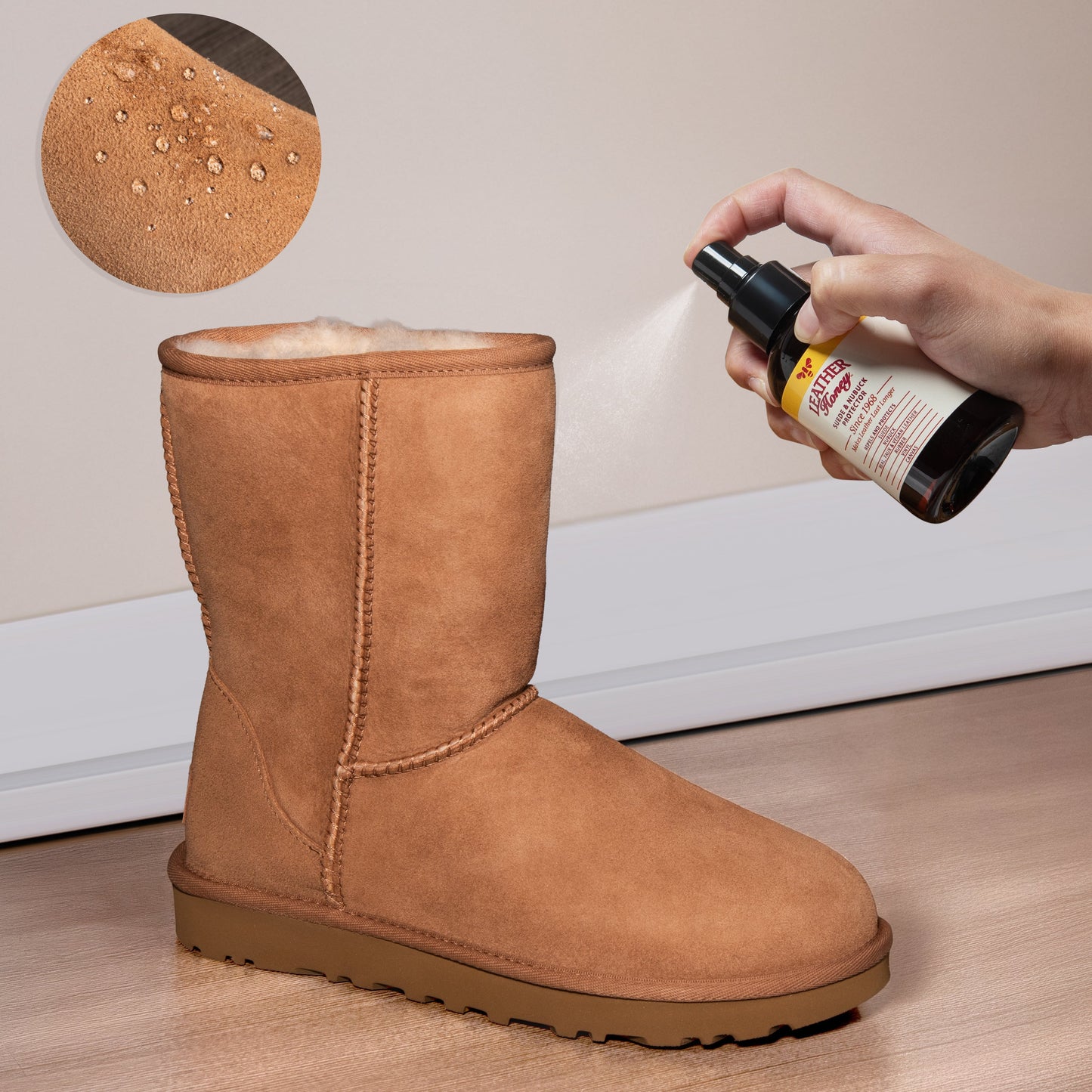Person applying a spray to a brown suede boot on a wooden floor.