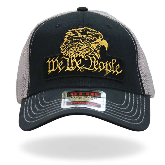 A black, gray, and yellow trucker hat with an 'We The People' eagle patch on the front.
