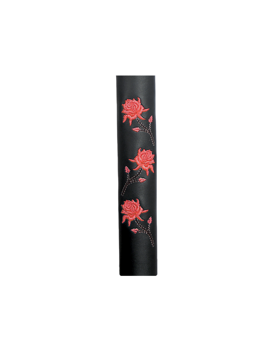 Black cylindrical leather hair tube product with red floral designs on a white background