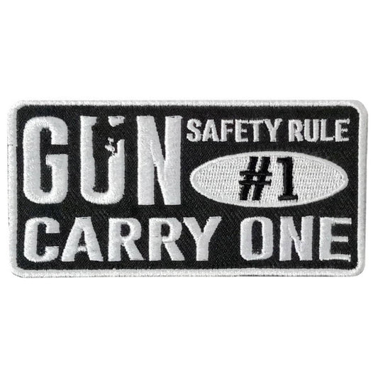 A black and white embroidered patch with the text 'GUN SAFETY RULE #1 CARRY ONE'.