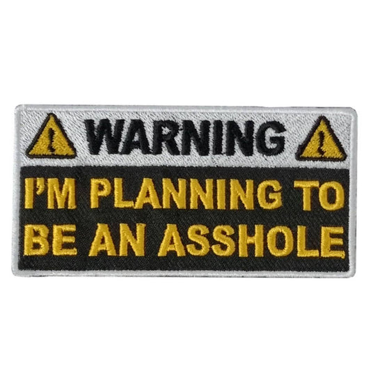 A rectangular embroidered patch with a warning sign design, black and yellow text, and the phrase 'I'M PLANNING TO BE AN ASSHOLE'.