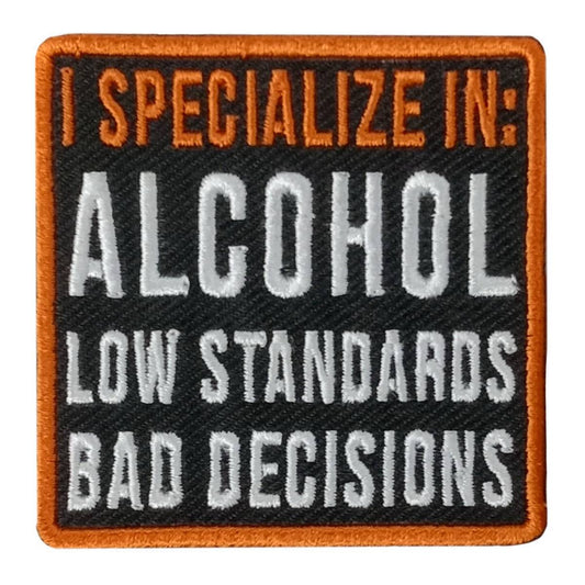A square patch with orange and black text that reads 'I SPECIALIZE IN: ALCOHOL LOW STANDARDS BAD DECISIONS'.