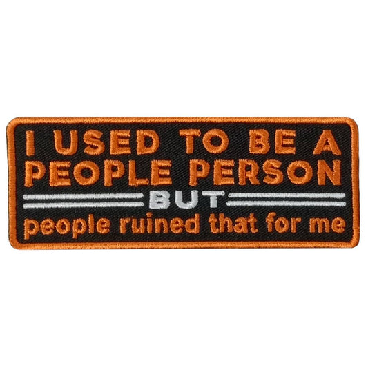 A rectangular embroidered patch with the text 'I USED TO BE A PEOPLE PERSON BUT people ruined that for me' on a black background with orange and white text.