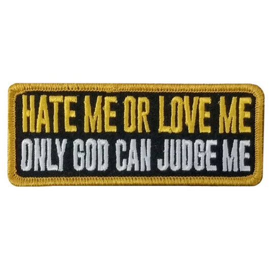 A rectangular embroidered patch with the text 'HATE ME OR LOVE ME ONLY GOD CAN JUDGE ME' in yellow and black colors on a white background.