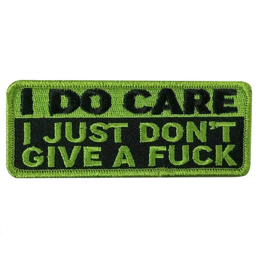 A rectangular embroidered patch with green background and black text, containing the phrase 'I DO CARE I JUST DON'T GIVE A FUCK'.