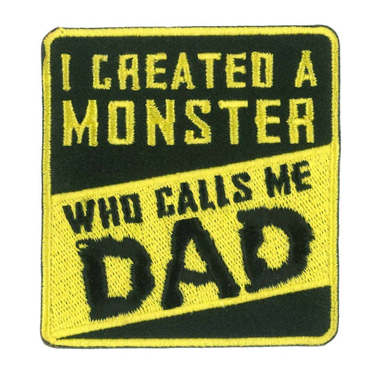 A embroidered patch with black and yellow text that reads: 'I CREATED A MONSTER WHO CALLS ME DAD'.
