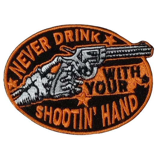 A patch with an embroidered design that includes text and a graphic of a hand with a firearm.