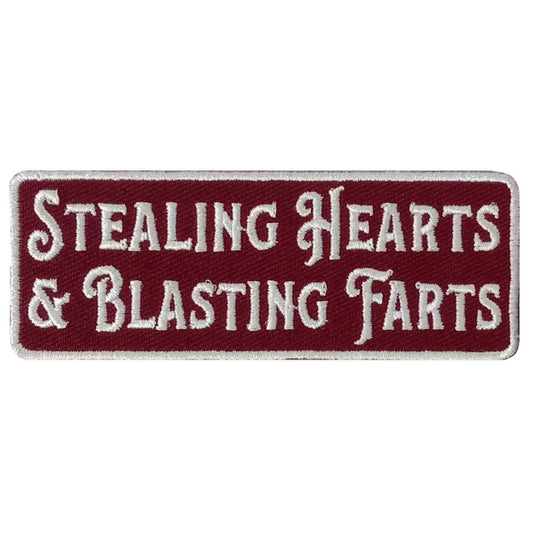 A maroon and white embroidered patch with the text 'STEALING HEARTS & BLASTING FARTS'.