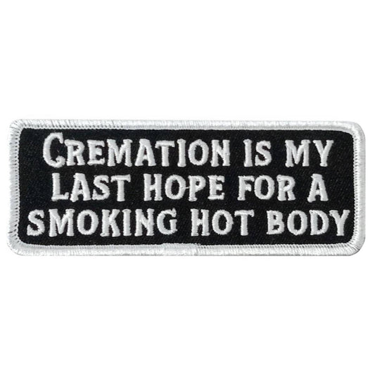 A rectangular black and white embroidered patch with the text 'CREMATION IS MY LAST HOPE FOR A SMOKING HOT BODY'.