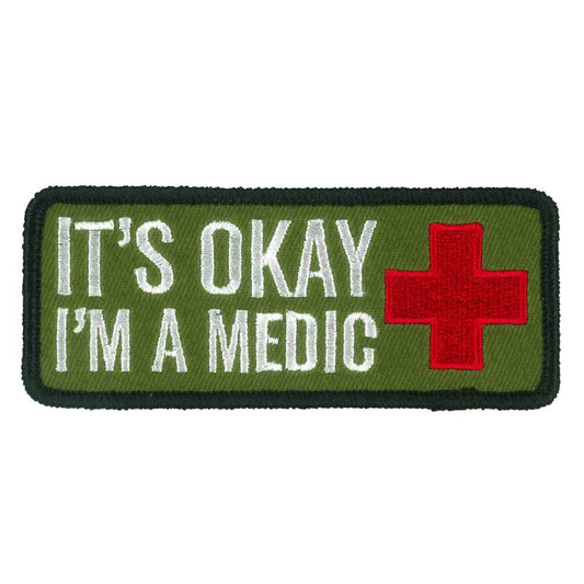 A rectangular embroidered patch with a green background, featuring the text 'IT'S OKAY I'M A MEDIC' and a red cross symbol.