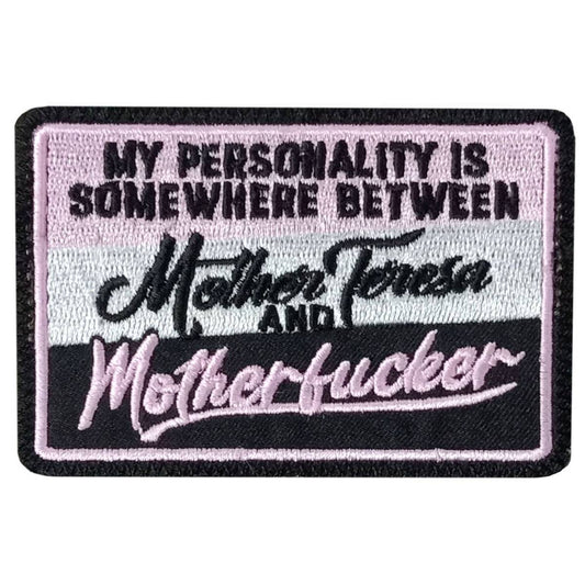 A black, white, and pink embroidered patch with the text 'MY PERSONALITY IS SOMEWHERE BETWEEN Mother Teresa and Motherfucker'.