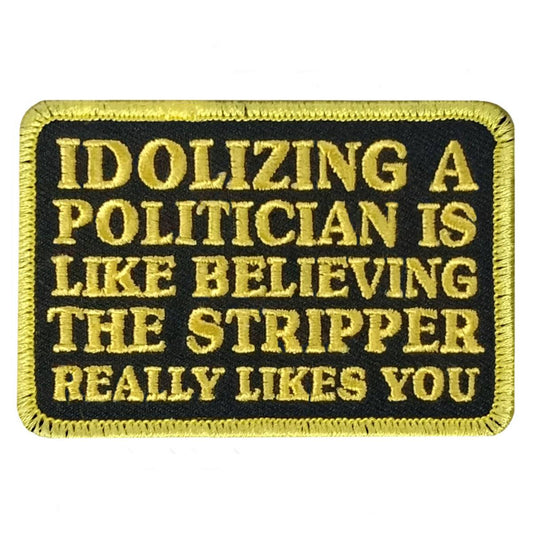 A rectangular black and yellow embroidered patch with the text 'IDOLIZING A POLITICIAN IS LIKE BELIEVING THE STRIPPER REALLY LIKES YOU'.